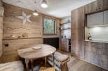 This charming kitchen boasts a rustic, inviting atmosphere with its wooden paneling and warm tones.