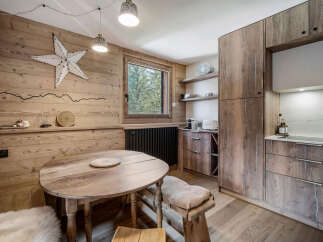 This charming kitchen boasts a rustic, inviting atmosphere with its wooden paneling and warm tones.