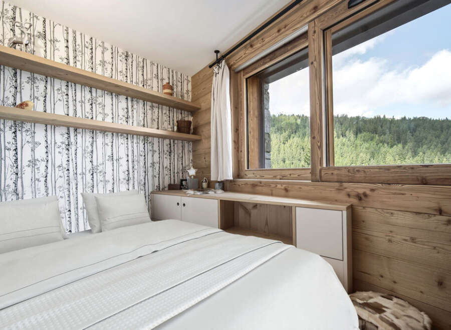 Experience the tranquility of this stunning bedroom, featuring a serene birch tree wallpaper and warm wooden accents.
