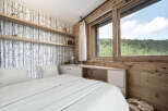 Experience the tranquility of this stunning bedroom, featuring a serene birch tree wallpaper and warm wooden accents.