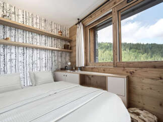 Experience the tranquility of this stunning bedroom, featuring a serene birch tree wallpaper and warm wooden accents.