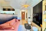 Discover modern living in this stylish property, featuring a beautifully designed living room with a cozy sofa and a unique gradient wall.