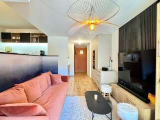 Discover modern living in this stylish property, featuring a beautifully designed living room with a cozy sofa and a unique gradient wall.