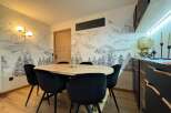 This stunning property features a modern dining area with a unique mountain-themed wallpaper, creating a cozy and inviting atmosphere.