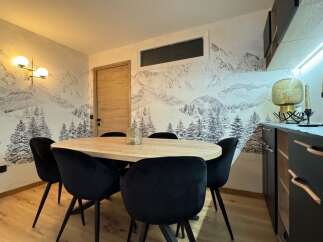 This stunning property features a modern dining area with a unique mountain-themed wallpaper, creating a cozy and inviting atmosphere.