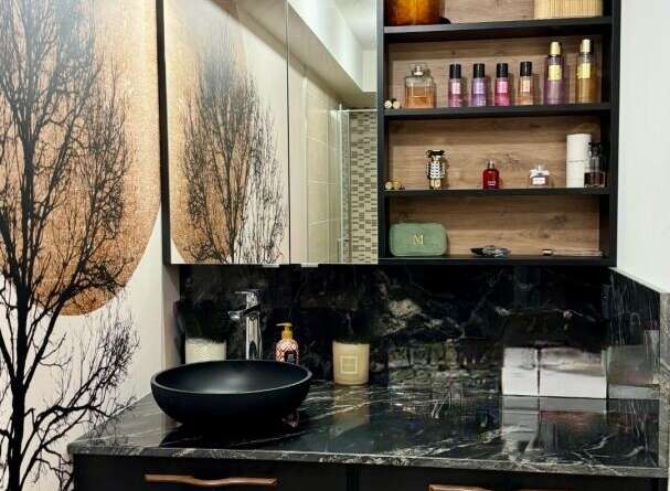 This modern bathroom boasts a sleek black vanity with a marble countertop, offering a luxurious and stylish space.