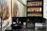 This modern bathroom boasts a sleek black vanity with a marble countertop, offering a luxurious and stylish space.