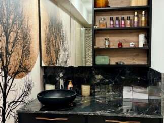This modern bathroom boasts a sleek black vanity with a marble countertop, offering a luxurious and stylish space.