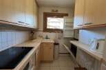 This charming kitchen features a modern cooktop, ample cabinet space, and a convenient sink area.
