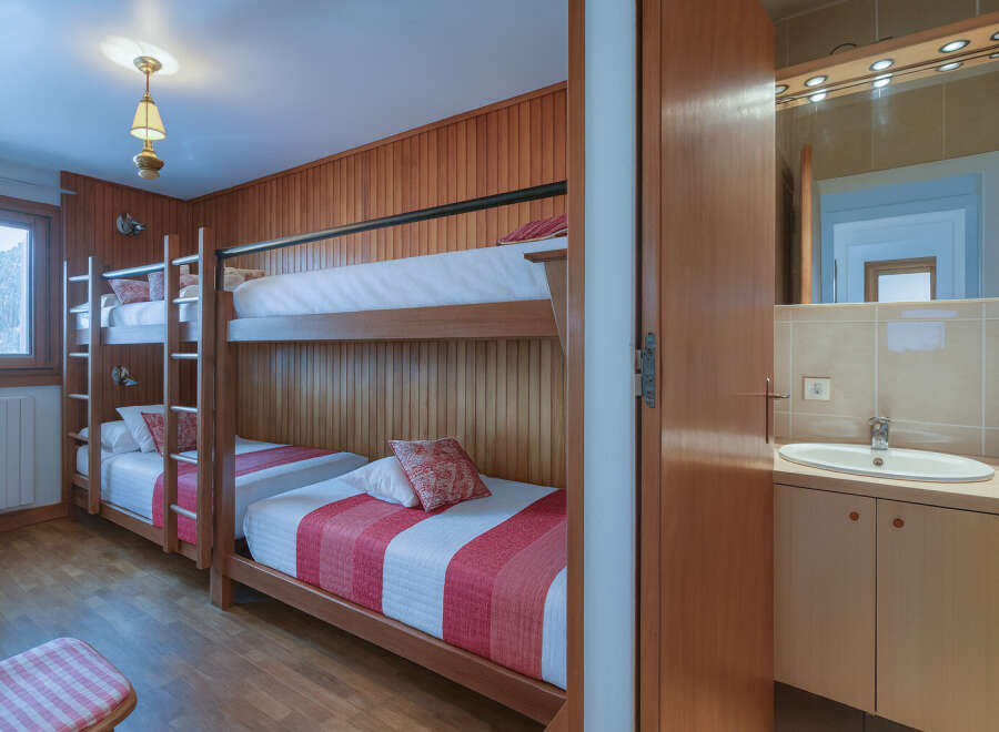This cozy bedroom features a unique bunk bed setup, perfect for families or groups.