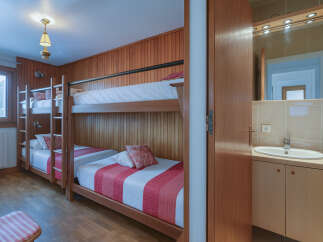 This cozy bedroom features a unique bunk bed setup, perfect for families or groups.