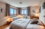 This cozy bedroom offers a serene retreat with stunning mountain views visible through the windows.