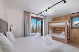 Experience luxury in this stunning bedroom featuring a cozy bunk bed and a comfortable king-size bed.