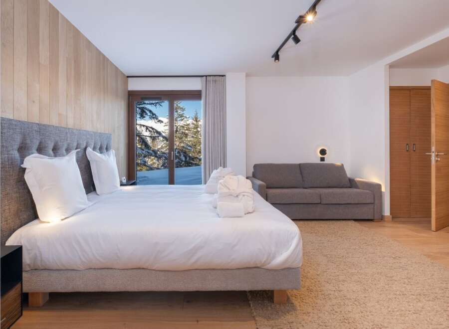 Experience luxury living in this stunning bedroom with breathtaking mountain views.
