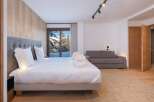 Experience luxury living in this stunning bedroom with breathtaking mountain views.