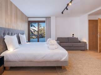Experience luxury living in this stunning bedroom with breathtaking mountain views.