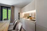 This modern kitchen boasts sleek, minimalist design with ample storage and a built-in oven.
