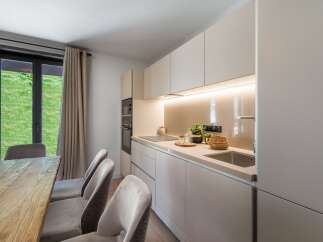 This modern kitchen boasts sleek, minimalist design with ample storage and a built-in oven.