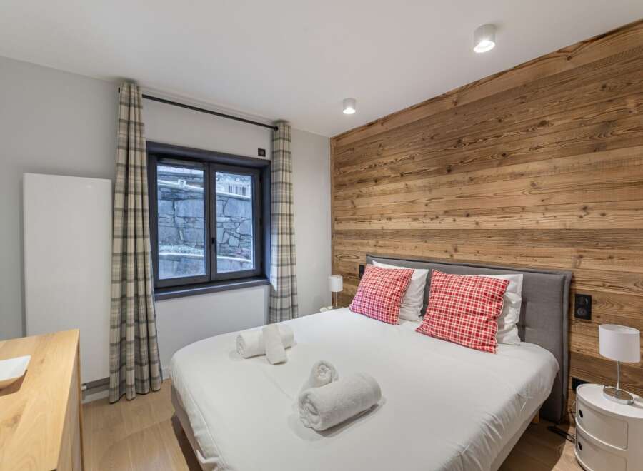 This cozy bedroom features a stunning wooden accent wall, creating a warm and inviting atmosphere.
