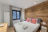 This cozy bedroom features a stunning wooden accent wall, creating a warm and inviting atmosphere.