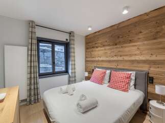 This cozy bedroom features a stunning wooden accent wall, creating a warm and inviting atmosphere.