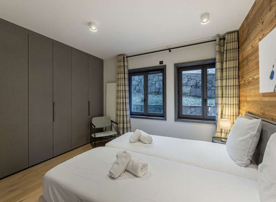 This cozy bedroom features two twin beds with crisp white linens, perfect for a comfortable stay.