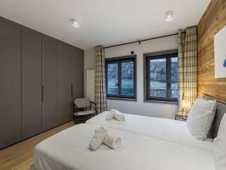 This cozy bedroom features two twin beds with crisp white linens, perfect for a comfortable stay.