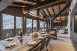 Experience luxury living in this stunning chalet, featuring a cozy fireplace and a spacious dining area perfect for entertaining.