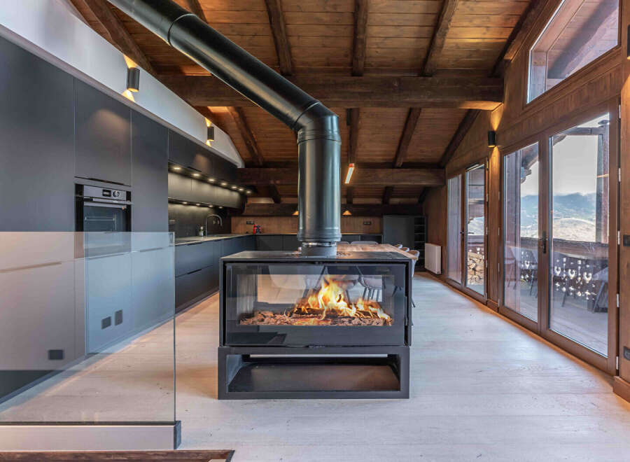 Experience luxury living in this stunning property featuring a modern kitchen and a cozy fireplace.