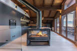 Experience luxury living in this stunning property featuring a modern kitchen and a cozy fireplace.