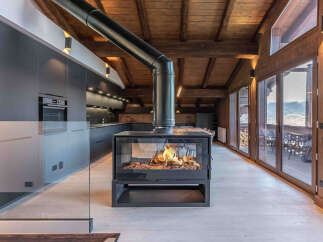 Experience luxury living in this stunning property featuring a modern kitchen and a cozy fireplace.