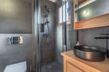 Step into this modern bathroom, featuring sleek gray tiles and a stylish black sink.
