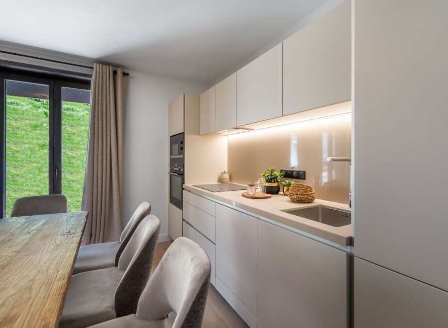 This modern kitchen boasts sleek, minimalist design with ample storage and a built-in oven.
