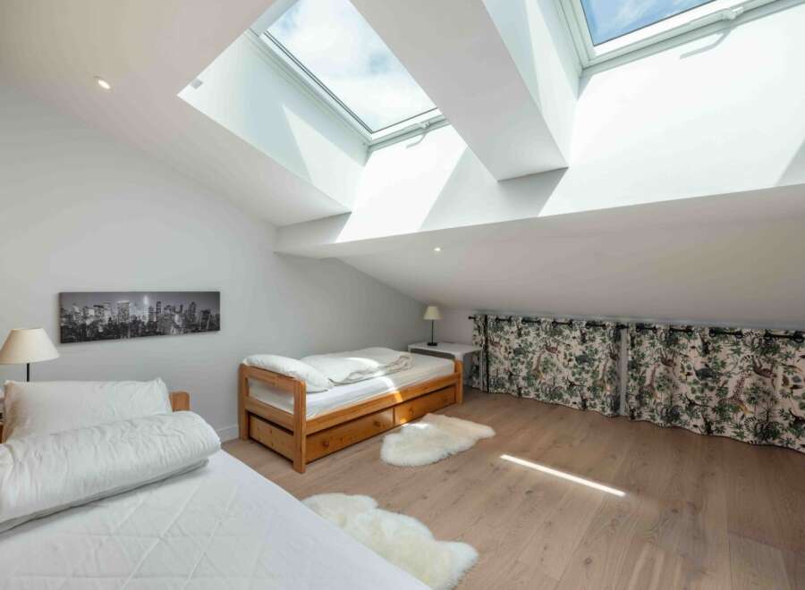 This stunning loft bedroom boasts natural light from the skylights, creating a bright and airy atmosphere.
