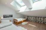 This stunning loft bedroom boasts natural light from the skylights, creating a bright and airy atmosphere.