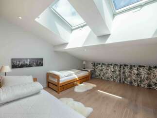 This stunning loft bedroom boasts natural light from the skylights, creating a bright and airy atmosphere.