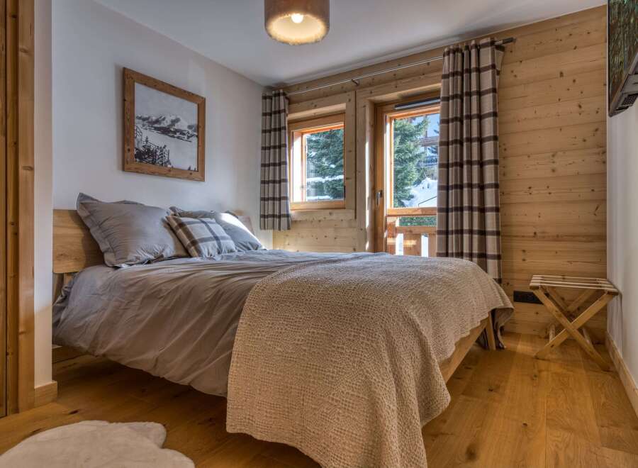 This cozy bedroom features a warm, inviting atmosphere with its wooden accents and neutral color palette.