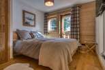 This cozy bedroom features a warm, inviting atmosphere with its wooden accents and neutral color palette.
