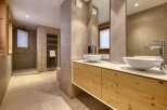 This luxurious bathroom features a modern design with a sleek vanity and two stylish sinks.