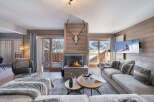 Experience luxury living in this stunning chalet, featuring a cozy fireplace and a spacious living area.