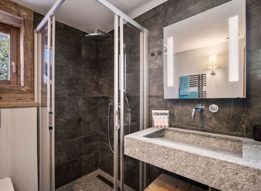 Step into luxury with this stunning bathroom featuring a modern shower and a sleek stone sink.