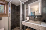 Step into luxury with this stunning bathroom featuring a modern shower and a sleek stone sink.