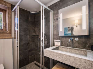 Step into luxury with this stunning bathroom featuring a modern shower and a sleek stone sink.