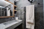 This modern bathroom features a sleek, gray stone sink and matching tiled walls, creating a sophisticated and minimalist aesthetic.