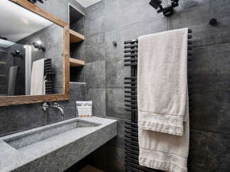 This modern bathroom features a sleek, gray stone sink and matching tiled walls, creating a sophisticated and minimalist aesthetic.