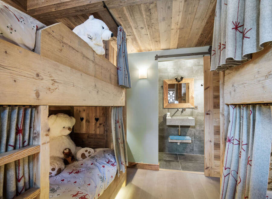 This charming bunk room features rustic wooden construction and cozy design elements, perfect for a mountain retreat.