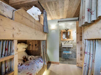 This charming bunk room features rustic wooden construction and cozy design elements, perfect for a mountain retreat.