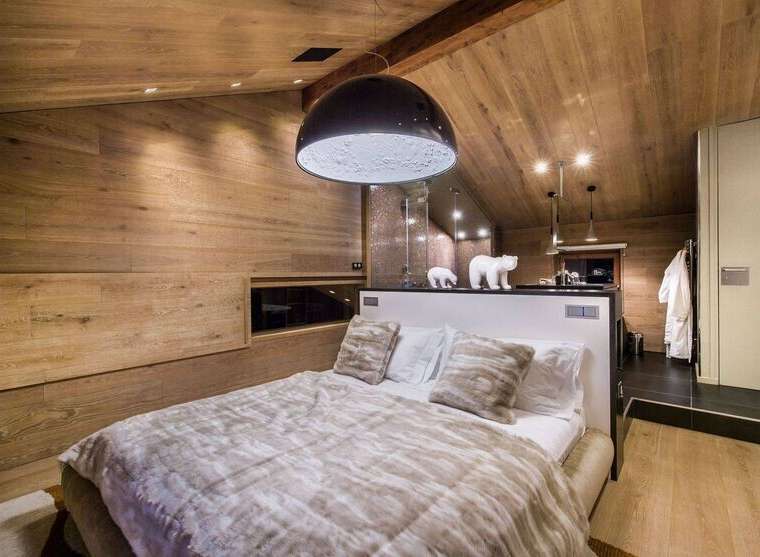 Experience luxury in this stunning bedroom featuring a unique moon-shaped pendant light and cozy bedding.