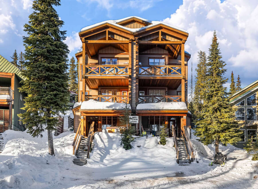 This stunning mountain property offers a luxurious retreat with its spacious balconies and inviting wooden architecture.
