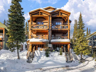 This stunning mountain property offers a luxurious retreat with its spacious balconies and inviting wooden architecture.